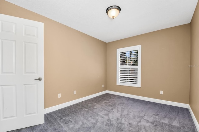 empty room featuring dark carpet