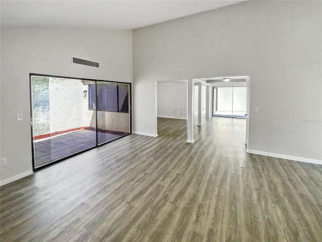 empty room featuring light wood-type flooring and high vaulted ceiling