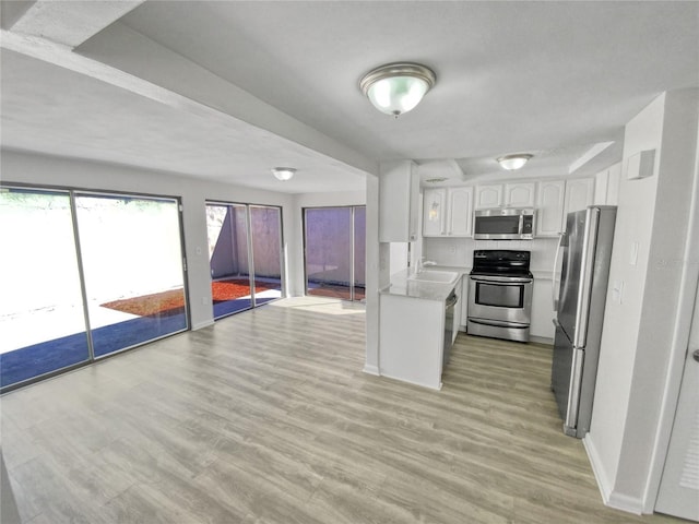 kitchen featuring white cabinets, light hardwood / wood-style floors, sink, and appliances with stainless steel finishes