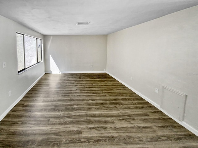 unfurnished room featuring dark wood-type flooring