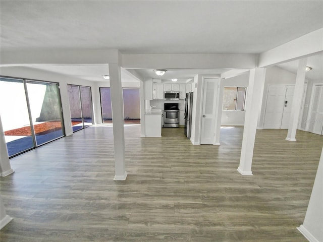 basement with stainless steel fridge and light wood-type flooring