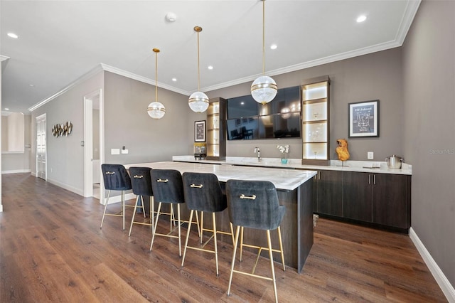 kitchen with dark brown cabinetry, a kitchen breakfast bar, a kitchen island, and dark hardwood / wood-style floors