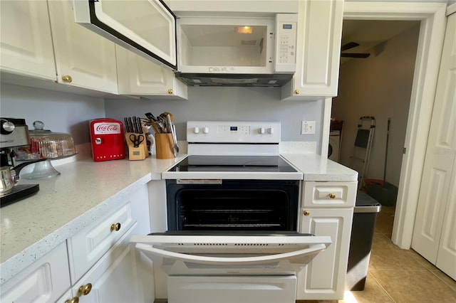 kitchen featuring white cabinetry, ceiling fan, white appliances, light tile floors, and light stone counters