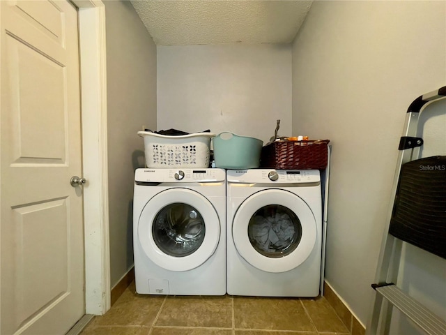 clothes washing area with independent washer and dryer and light tile floors