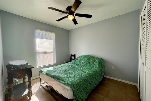 tiled bedroom with a closet and ceiling fan