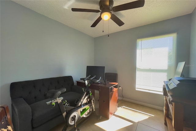 interior space featuring light tile flooring, ceiling fan, and a textured ceiling