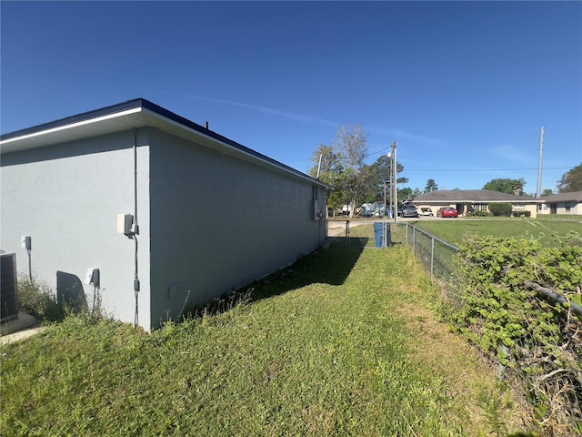 view of side of property with a yard and central AC unit