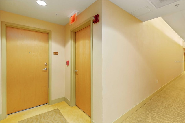 hall with light colored carpet