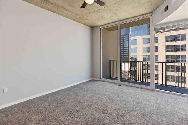 carpeted empty room with a wall of windows and ceiling fan