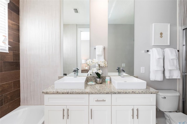 full bathroom featuring tiled shower / bath combo, double vanity, and toilet