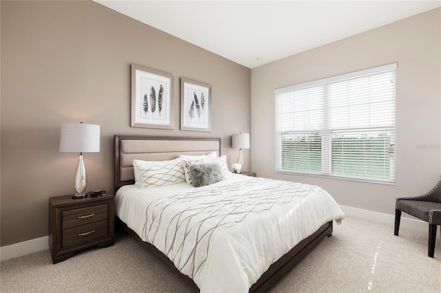 bedroom with multiple windows and light colored carpet