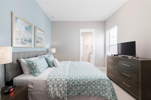 bedroom with light carpet and ensuite bath