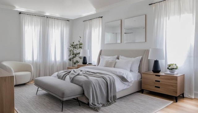 bedroom featuring ornamental molding and light hardwood / wood-style floors