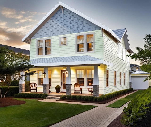 view of front of house featuring covered porch and a yard