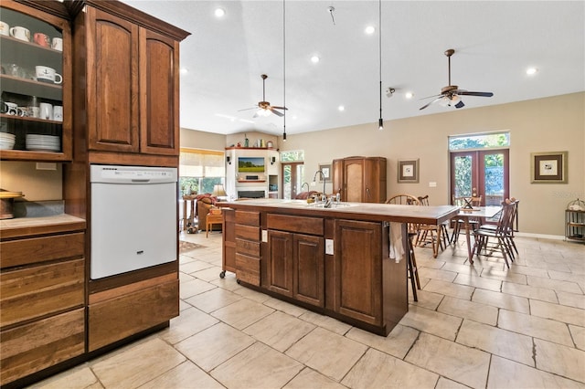 kitchen featuring dishwasher, an island with sink, a kitchen breakfast bar, light countertops, and a sink