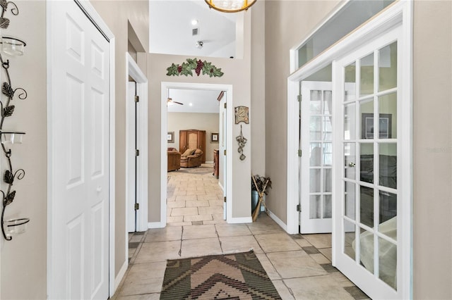 doorway featuring baseboards and light tile patterned floors