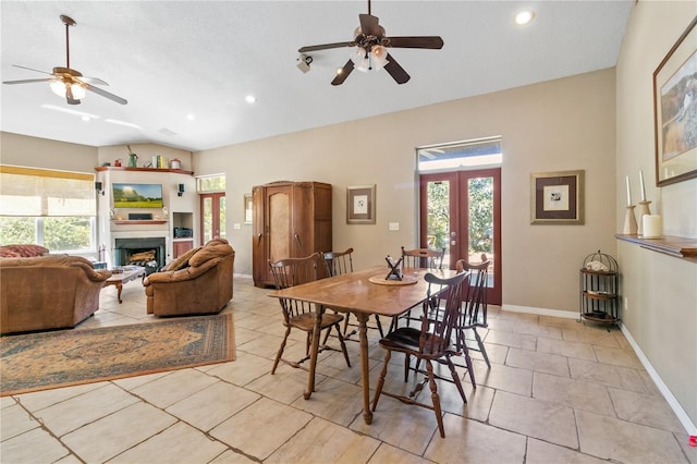 dining space featuring plenty of natural light, a fireplace, baseboards, and french doors