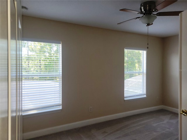 carpeted spare room featuring ceiling fan