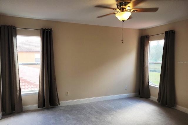 carpeted spare room featuring ceiling fan