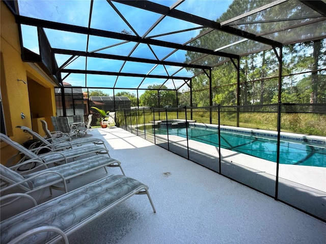 view of pool with glass enclosure and a patio