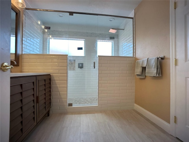 bathroom with a shower with door, vanity, and hardwood / wood-style floors