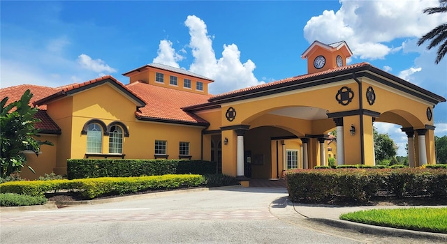 mediterranean / spanish-style home featuring driveway, a tiled roof, and stucco siding