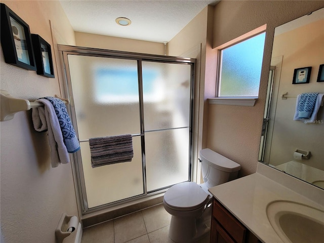 bathroom with tile patterned floors, vanity, toilet, and a shower with shower door