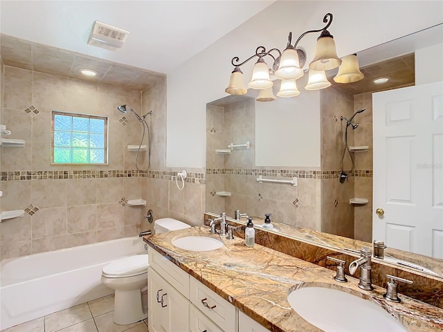 full bathroom with tile patterned floors, vanity, tile walls, toilet, and tiled shower / bath