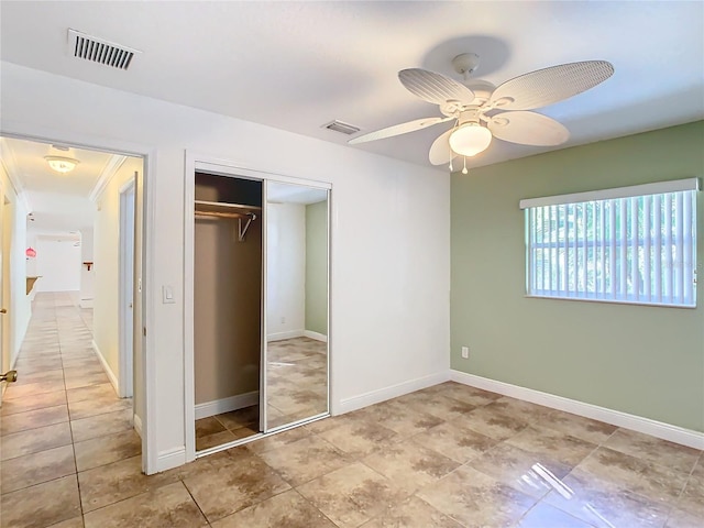 unfurnished bedroom featuring ceiling fan and a closet