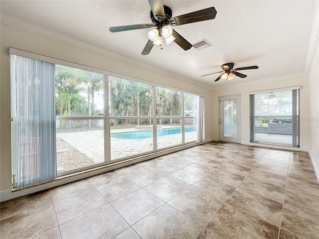 unfurnished sunroom featuring ceiling fan