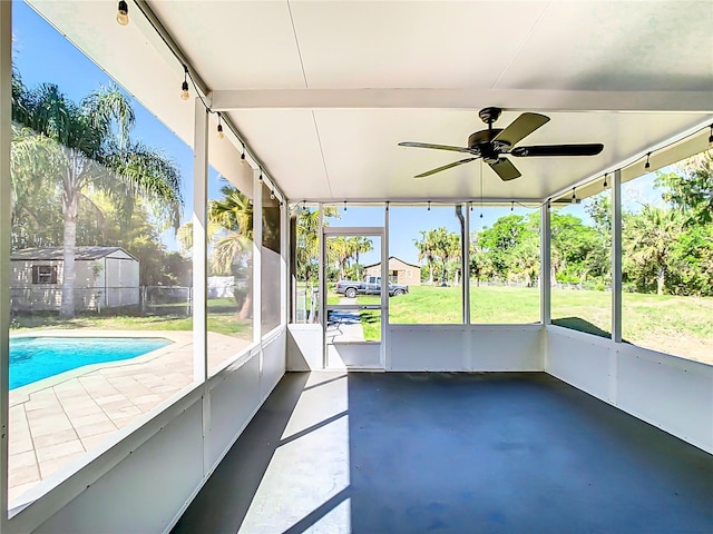 unfurnished sunroom with ceiling fan