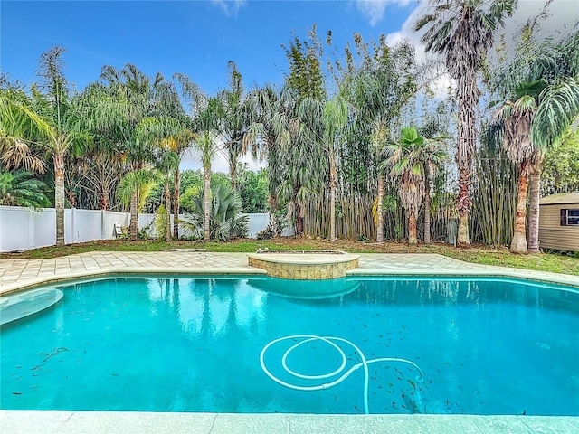 view of swimming pool with an in ground hot tub