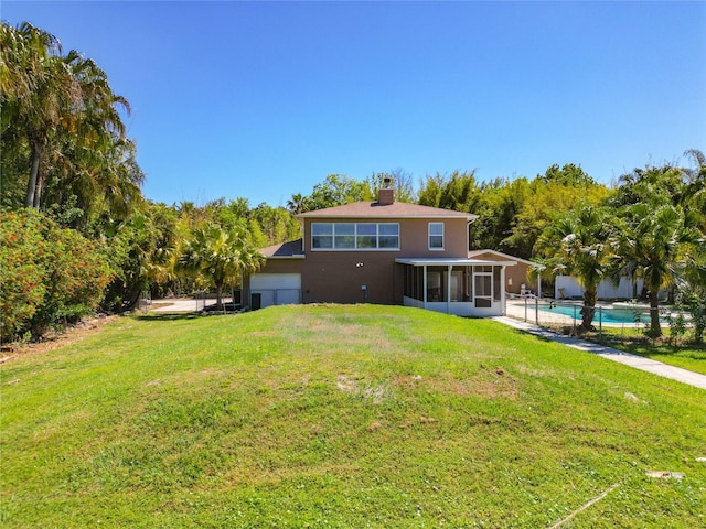 back of property featuring a lawn and a sunroom