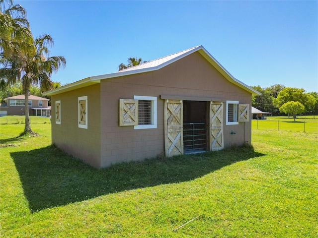 back of house featuring an outdoor structure and a yard