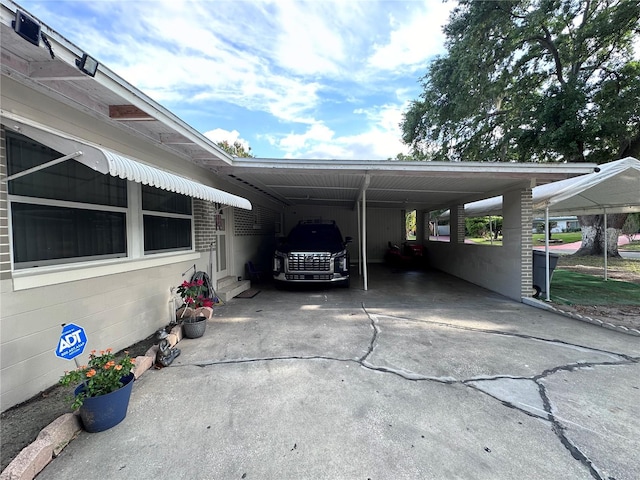 view of parking / parking lot featuring an attached carport and driveway