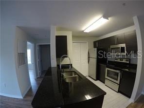 kitchen with refrigerator, electric range oven, and sink