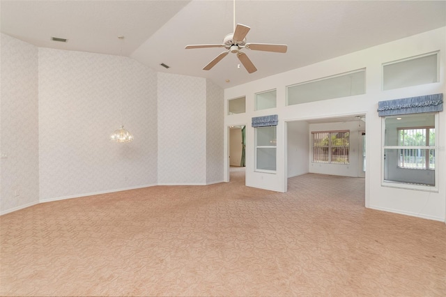 unfurnished room with light carpet, high vaulted ceiling, and ceiling fan with notable chandelier