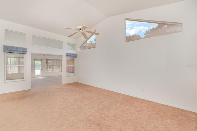 carpeted spare room featuring ceiling fan and high vaulted ceiling