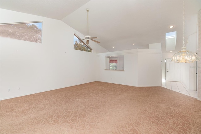 empty room featuring lofted ceiling, light colored carpet, and ceiling fan with notable chandelier