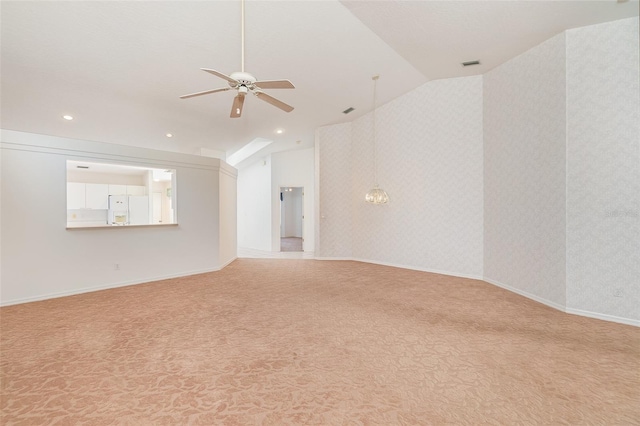 unfurnished room with ceiling fan, vaulted ceiling, and light colored carpet