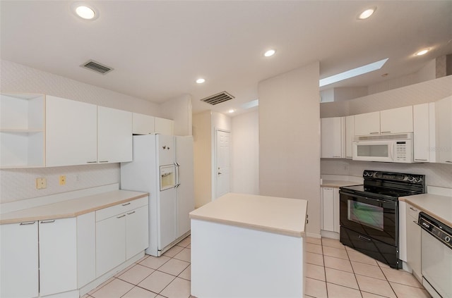 kitchen with white appliances, white cabinets, a kitchen island, and light tile flooring