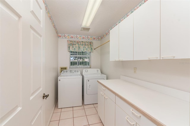 washroom featuring hookup for a washing machine, independent washer and dryer, light tile floors, and cabinets