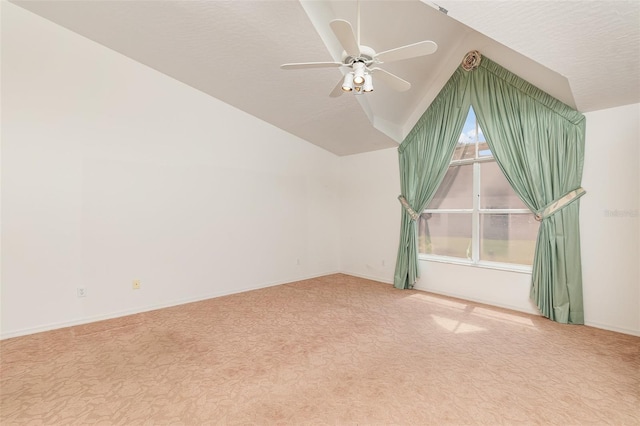 empty room featuring light carpet, lofted ceiling, a textured ceiling, and ceiling fan