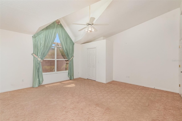 carpeted spare room featuring ceiling fan and vaulted ceiling