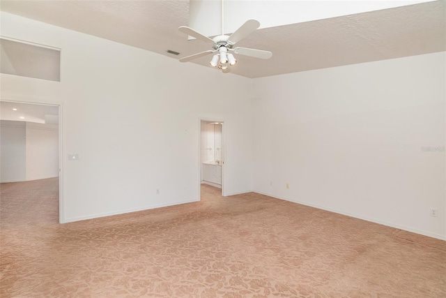 empty room with light carpet, high vaulted ceiling, and ceiling fan