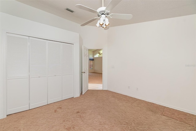 unfurnished bedroom with a closet, light carpet, and ceiling fan