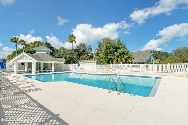 view of swimming pool featuring a patio area and an outdoor structure