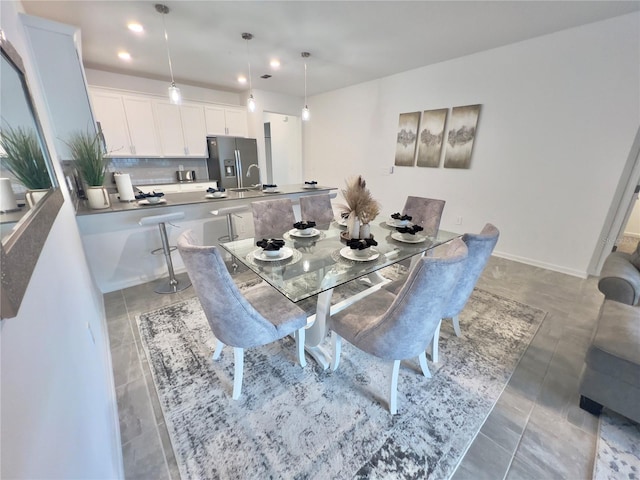 dining room with dark tile patterned floors and sink