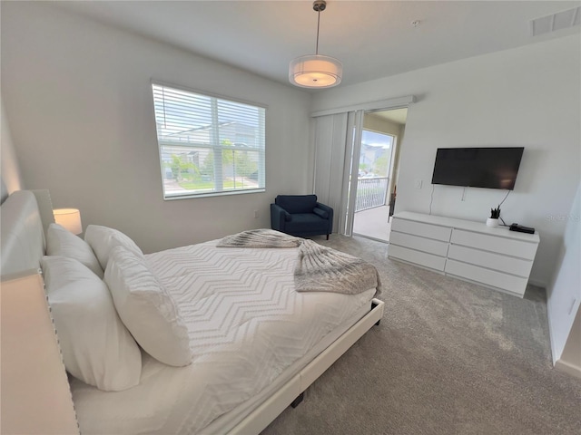 carpeted bedroom featuring access to exterior and visible vents