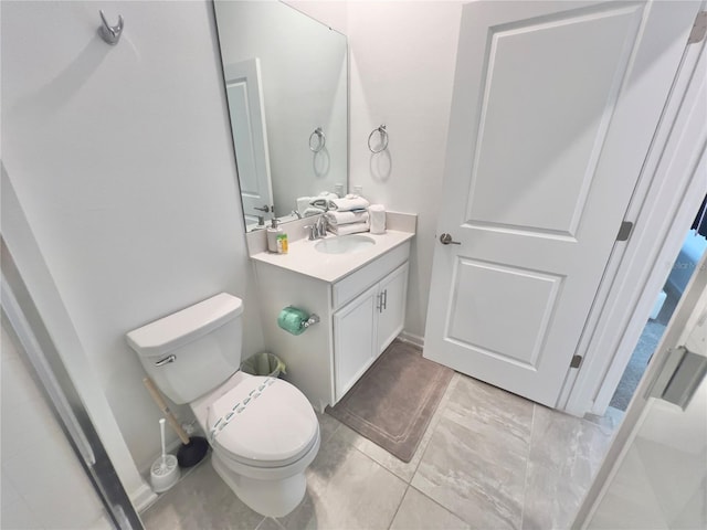 bathroom with tile patterned flooring, vanity, and toilet